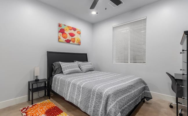 Grey striped quilt set on a bed in a furnished room rental